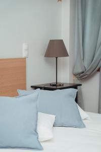 a bed with white pillows and a table with a lamp at Great Apartment Belavista in Leça da Palmeira +20 photos