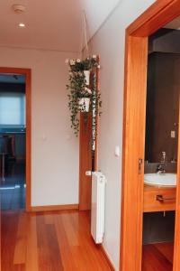 a bathroom with a sink and a door with a plant at Great Apartment Belavista in Leça da Palmeira