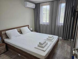 a bedroom with a large bed with towels on it at Къща за гости SUNNY HILL in Varna City +18 photos