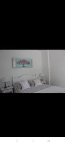 biała sypialnia z łóżkiem z 2 poduszkami w obiekcie Cozy apartment in Puerto de Naos 45 m² mountain view w mieście Puerto Naos