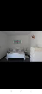 biała sypialnia z łóżkiem i komodą w obiekcie Cozy apartment in Puerto de Naos 45 m² mountain view w mieście Puerto Naos