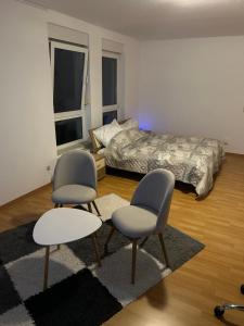 a bedroom with two chairs and a bed at Schöne Wohnung für Tagesgäste, Studenten oder Handwerker, Chemnitz Gablenz, ÖPNV direkt vor der Tür, Internet & TV inkl in Chemnitz