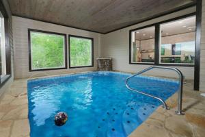 a large swimming pool in a room with windows at Majestic Pines Lodge in Sevierville