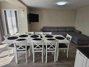 a dining room with a table and chairs and a couch at Къща за гости SUNNY HILL in Varna City