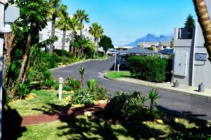 an empty street with palm trees and a road at West Beach Luxury Apartment in Bloubergstrand