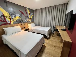 Postel nebo postele na pokoji v ubytování Ramada Encore Ponta Grossa