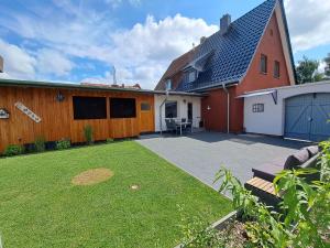 einen Hinterhof mit einer Terrasse und einem Haus in der Unterkunft Ferienhaus Mandelbäumchen in Barth