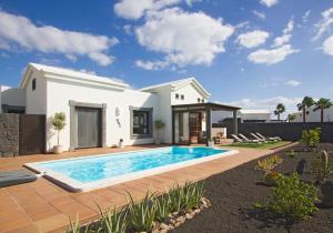 a villa with a swimming pool in a yard at Villas Coral Deluxe in Playa Blanca