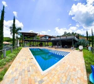 ein großes Schwimmbad vor einem Haus in der Unterkunft Rancho em Nazaré Paulista, Brasil in Quadra