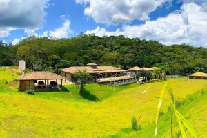 ein Haus auf einem grasbewachsenen Hügel mit einem Fußballfeld in der Unterkunft Rancho em Nazaré Paulista, Brasil in Quadra