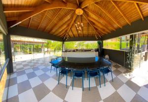eine Terrasse mit einem Tisch und Stühlen unter einem Dach in der Unterkunft Rancho em Nazaré Paulista, Brasil in Quadra