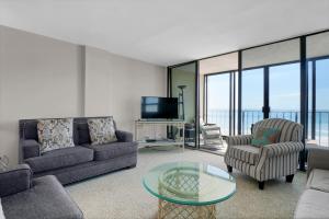 uma sala de estar com um sofá, cadeiras e uma TV em The Islander - 6F by Sea Scape Properties em Wrightsville Beach