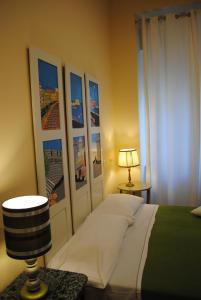 ナポリにあるLe Stanze di Angelaのベッドルーム1室(ベッド1台付)が備わります。壁には絵画が飾られています。