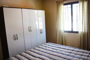 1 dormitorio con cama, armarios y ventana en Dulce Hogar, en Mendoza