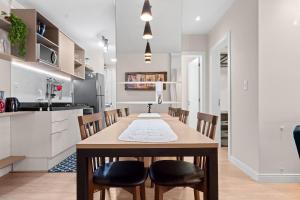 a kitchen and dining room with a wooden table and chairs at Campos de Canela 1 dorm na Rua Coberta by Achei in Canela