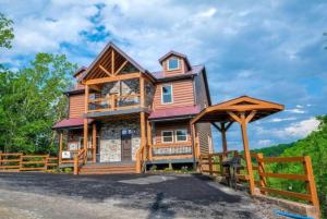 a large wooden house with a wooden fence at Majestic Pines Lodge in Sevierville