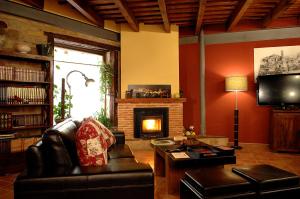 a living room with a couch and a fireplace at Los Cuatro Caños in Sigüenza