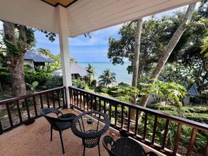 a balcony with chairs and a table and the ocean at Lamai Bayview Boutique Resort in Lamai