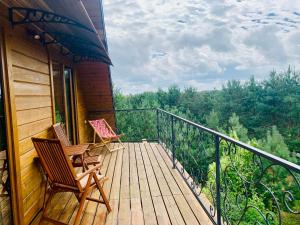 a balcony with two chairs and a view of the forest at Sosnogródek in Rutka Tartak