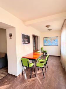 a conference room with a wooden table and green chairs at Vernisaj apt at Republic Square & Ruben tours in Yerevan