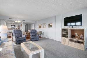 uma sala de estar com um sofá, cadeiras e uma TV em The Islander - 9F by Sea Scape Properties em Wrightsville Beach