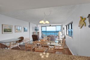 uma sala de jantar e sala de estar com mesa e cadeiras em The Islander - 9F by Sea Scape Properties em Wrightsville Beach