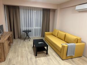 a living room with a yellow couch and a table at NIKA The architect DIAMOND OF GEVGELIA in Gevgelija