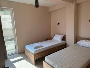 a bedroom with two beds and a window at NIKA The architect DIAMOND OF GEVGELIA in Gevgelija