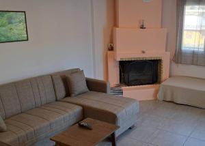 a living room with a couch and a fireplace at Sapfous apartment in Igoumenitsa