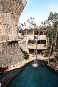 an external view of a building with a pool of water at Taio Tulum in Tulum +23 photos