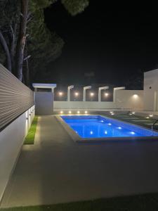 a swimming pool in a backyard at night at Pervolia Oasis Villa in Kiti