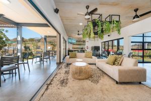 a living room with couches and a table and chairs at Ballito Village Luxury Apartments by DropInn in Ballito