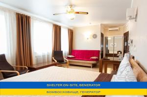 a bedroom with a bed and a red couch at Antwo-Hotel in Kharkiv