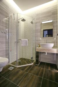 a bathroom with a shower and a sink and a toilet at Hotel Theater Belgrade in Belgrade