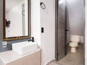 Un baño con lavabo e inodoro en Adhoc Cintermex, en Monterrey 27 fotos más