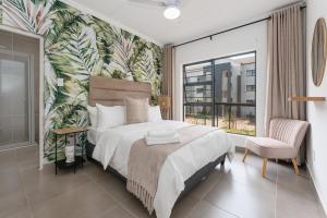 a bedroom with a large bed and a large window at Ballito Village Luxury Apartments by DropInn in Ballito +95 photos
