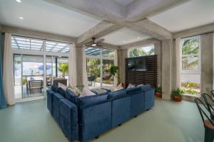a living room with a blue couch and windows at Oceanfront 3 Bedroom - Conmigo Villas South in Maya Beach