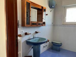 Un baño con un lavabo azul y un inodoro. en Villa Eucalipti sul mare, en Bari 31 fotos más