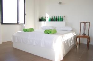 uma cama branca com almofadas verdes em cima em Sul Colle em Moricone