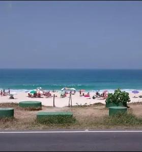 a beach with a bunch of people on the beach at SCR-Saquarema-Pousada da Tia Lúcia à Beira Mar in Saquarema