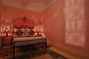 a bedroom with a bed with a red head board at Riad La Famille in Marrakesh