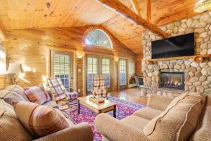 a living room with a stone fireplace in a log cabin at The Alpine Lodge in North Creek