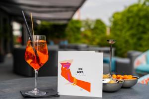 a wine glass sitting on a table with a menu at The Aries Hotel in Vicenza