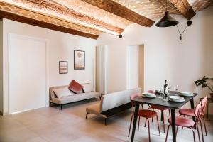 a living room with a table and chairs and a couch at Vicolo Al Castello - Langhe e Monferrato Suites in Costigliole dʼAsti