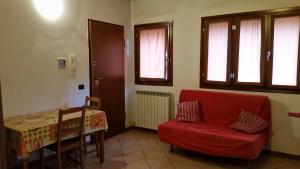 sala de estar con silla roja y mesa en Casa Collecchio, en Collecchio