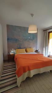 Costa dʼOnegliaにあるCasa Gelsominoのベッドと壁に絵が飾られた寝室