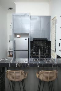 a kitchen with a counter with two stools at Villa indah in Beber