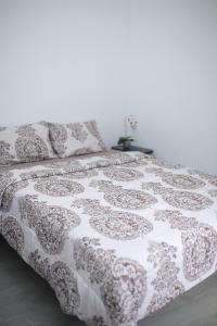 a bed with a black and white comforter and pillows at Villa indah in Beber +27 photos