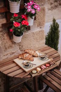 a table with a tray of bread and some flowers at DONNA LAURA - Holiday Home in San Quirico dʼOrcia +37 photos