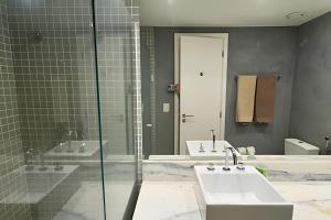 a bathroom with two sinks and a glass shower at Flats Aconchegantes na Barra da Tijuca, Link Stay in Rio de Janeiro